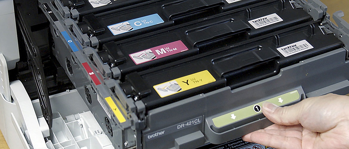 Persoana deschide imprimanta cu cartuse de toner