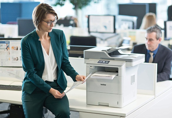 Angajată la birou alături de imprimantă Brother MFC-L6900DW