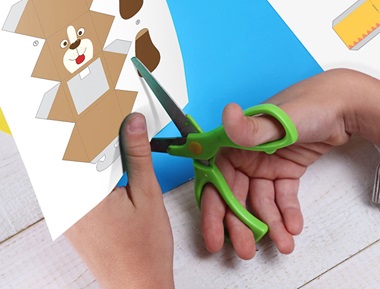 Persoană ce decupează imaginea unui câine de pe creative centre 