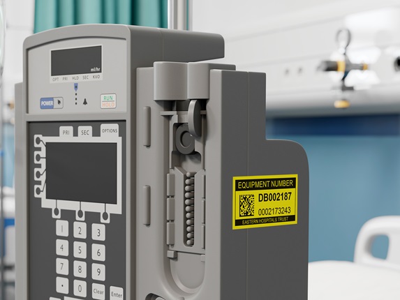 Etichetă de inventar Brother P-touch negru pe galben pe echipament medical